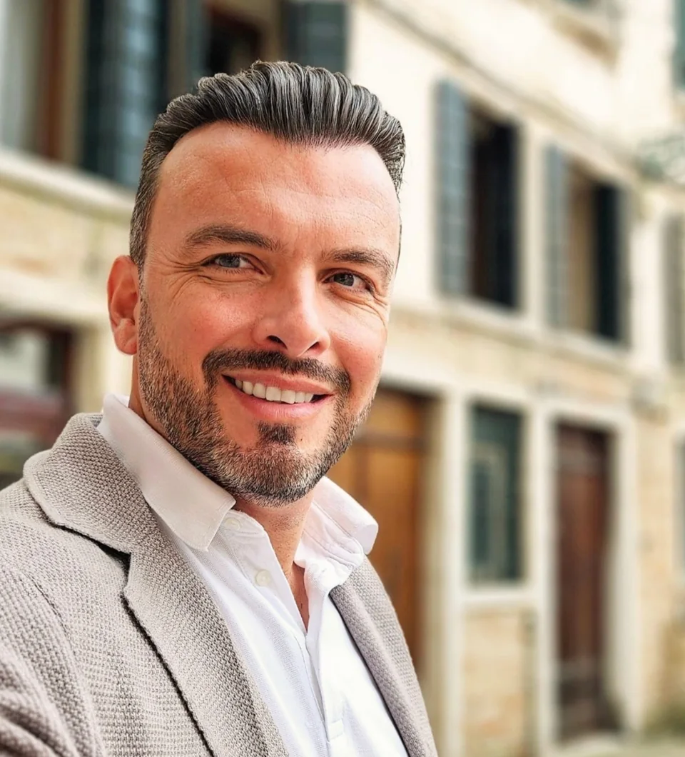 Sasha Rojnik smiling on a street in Italy